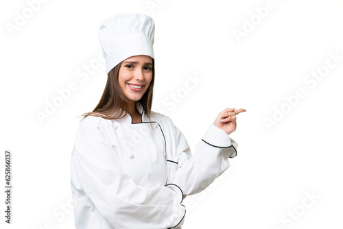 Young chef caucasian woman over isolated background pointing finger to the side photo