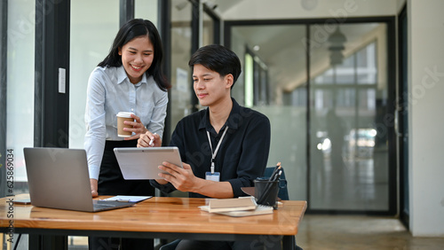 A handsome Asian male office worker is talking and sharing his ideas with a female colleague