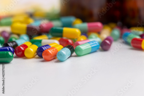 pill bottles without labels and many capsules placed on a white background