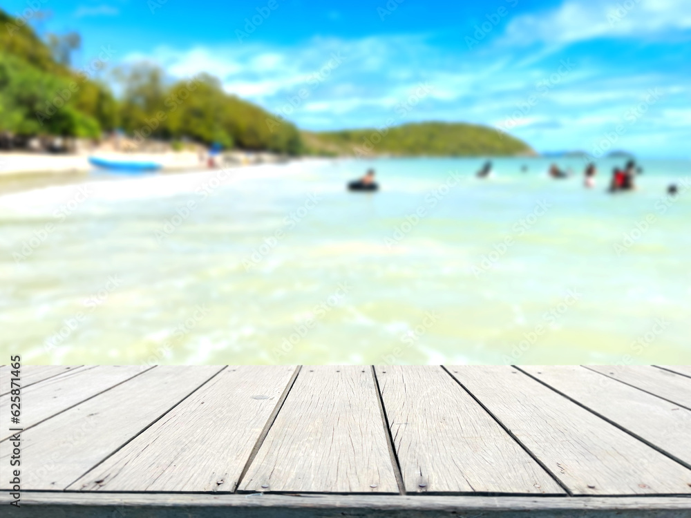 Fototapeta premium Wooden table, in blurred sea background