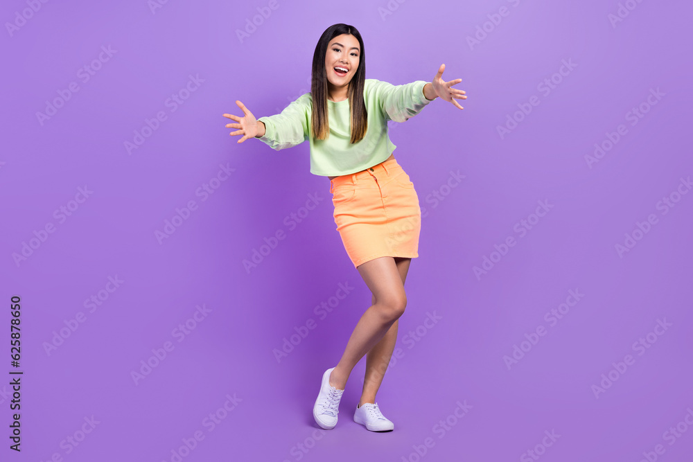Naklejka premium Full size photo of satisfied good mood woman dressed green shirt stylish skirt stretching arms to you isolated on purple color background