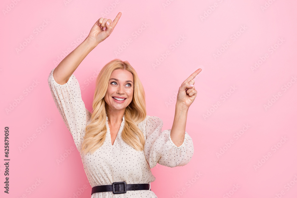 Photo of mature satisfied gorgeous pretty woman wearing trendy white glamour dress point fingers mockup news isolated on pink background Photo of mature satisfied gorgeous pretty woman wearing trendy white glamour dress point fingers mockup news isolated on pink background
