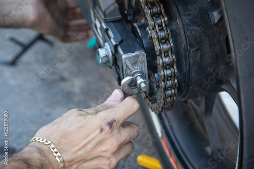 Man repairing motorcycle chain. Sport. Hobby