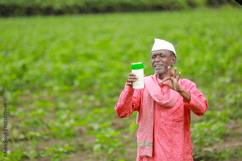 Fototapeta premium Indian happy farmer holding empty Bottle in hands, happy farmer showing white Bottle