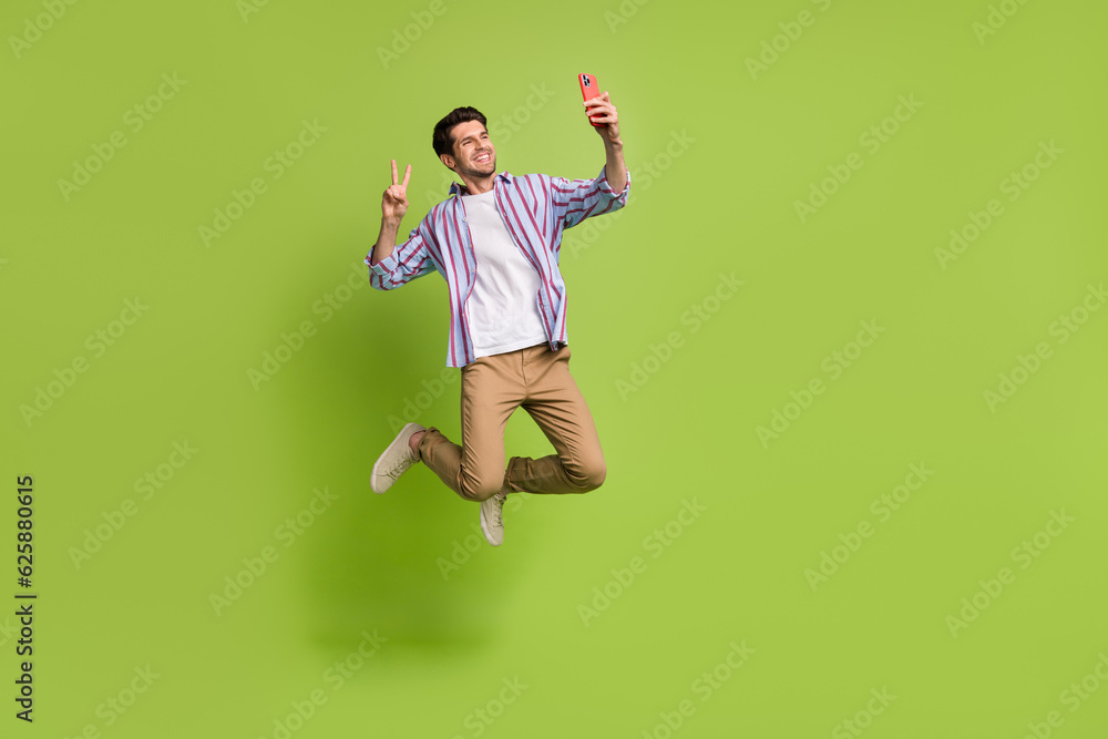 Φωτογραφία Full length body photo of funky young man positive jumping showing v sign blogge