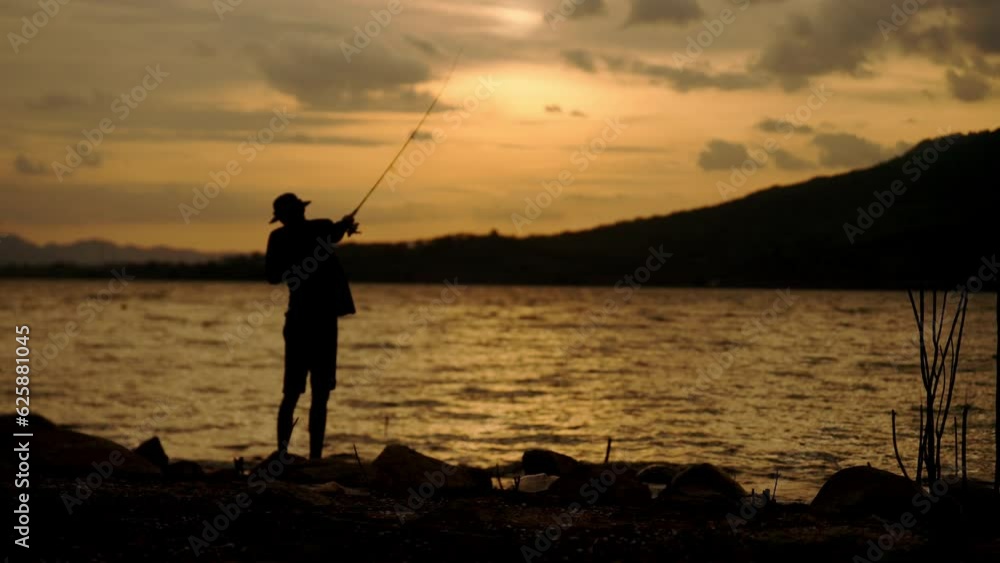 Silhouette of fishermen alone recreation with fishing rod outdoor catching lifestyle fish at sunset Silhouette of fishermen alone recreation with fishing rod outdoor catching lifestyle fish at sunset