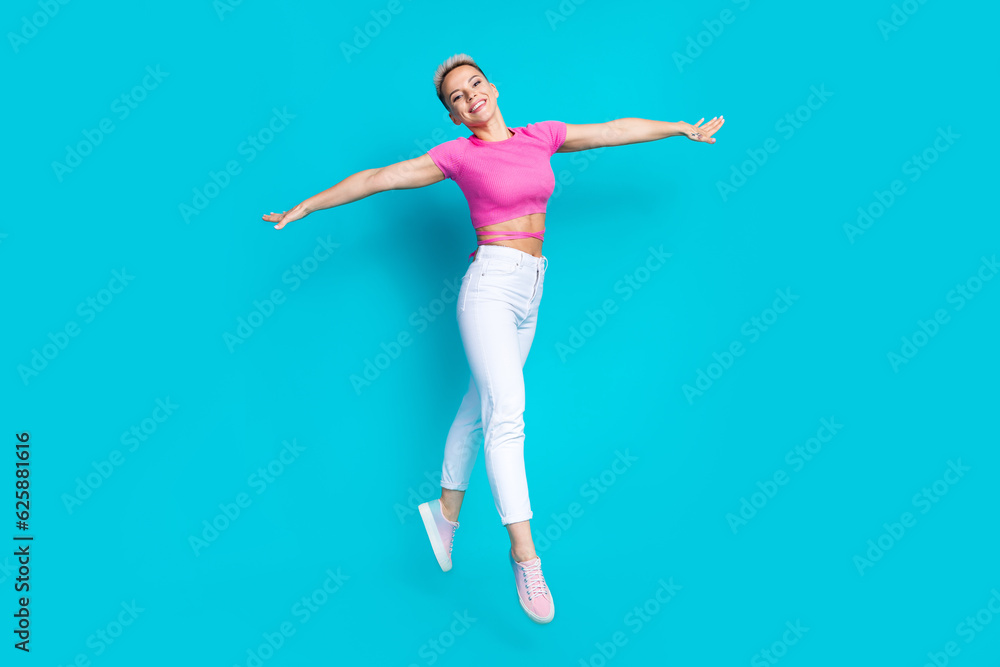 Full length photo of lovely young lady spread hands walk flight bird plane wear trendy pink garment isolated on aquamarine color background Full length photo of lovely young lady spread hands walk flight bird plane wear trendy pink garment isolated on aquamarine color background