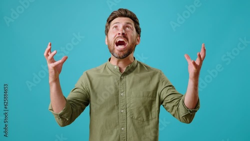 Aggressive bearded man looks around and shouts waving hands photo
