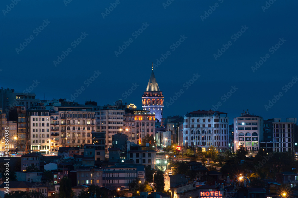 The Istanbul skyline with the iconic Galata Tower lit up at night on the European side of the Bosporus straight, Turkey. .
