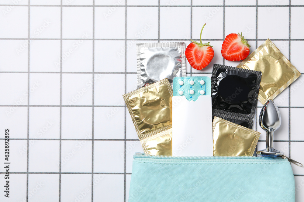 Handbag with condoms and birth control pills, place for text Handbag with condoms and birth control pills, place for text