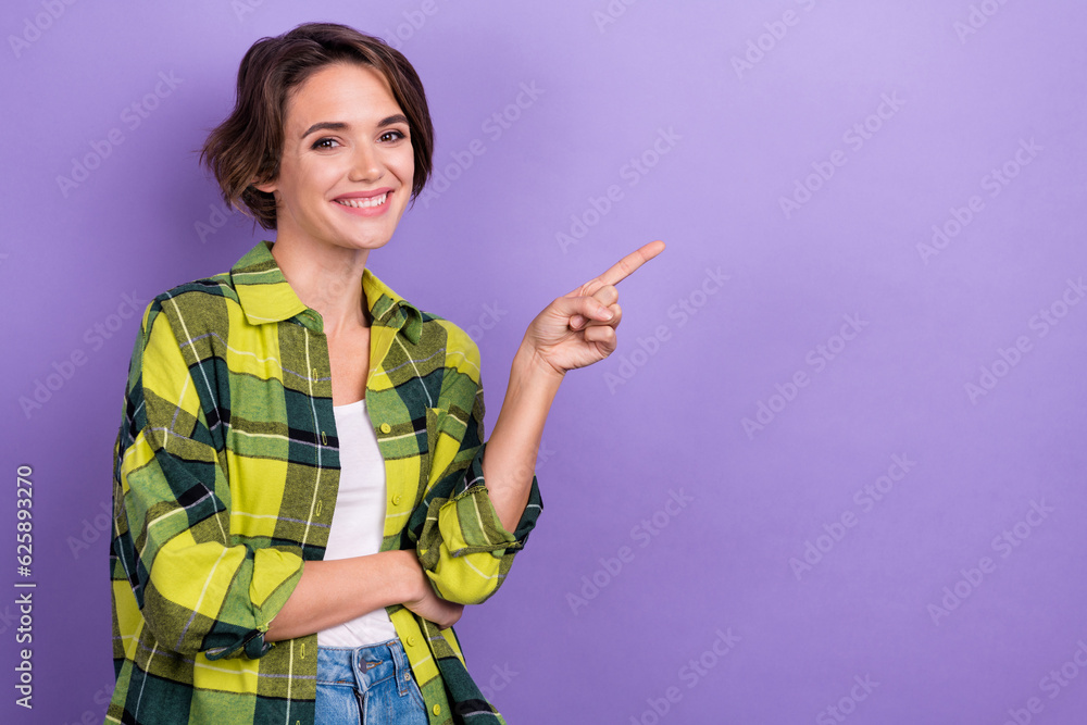 Photo of young smile cute woman wear checkered stylish jacket directing finger empty space presentation isolated on purple color background Photo of young smile cute woman wear checkered stylish jacket directing finger empty space presentation isolated on purple color background