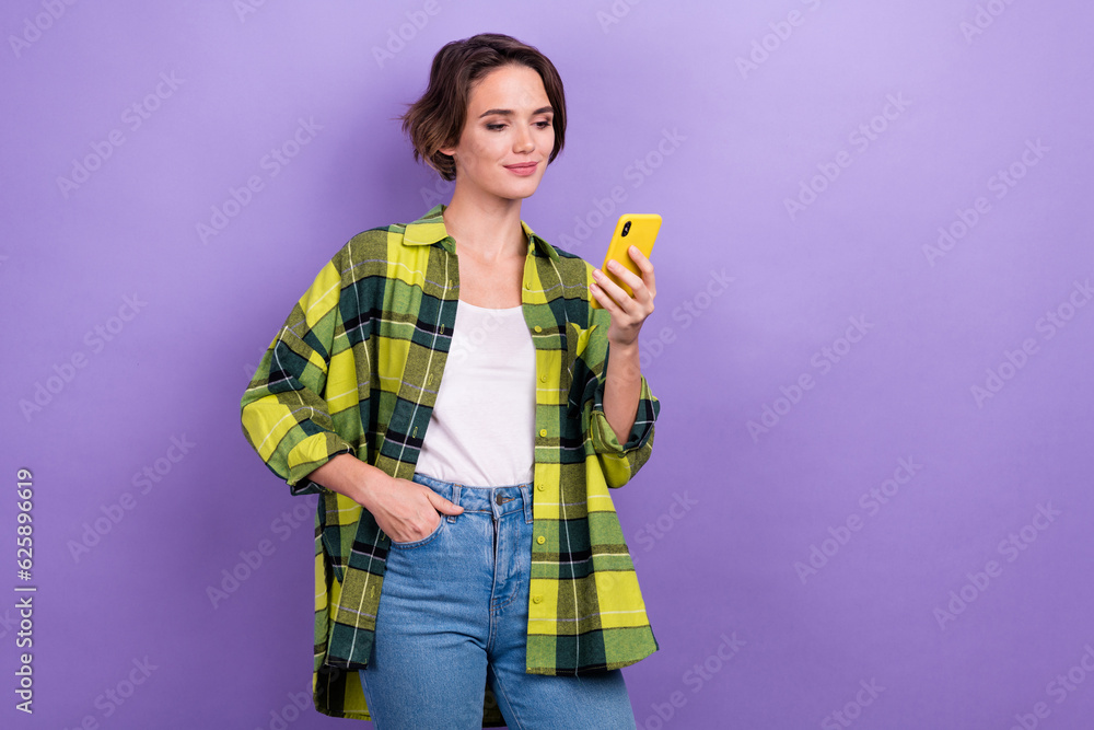 Photo of confident young lady reading new internet media online hold smartphone browsing gadget isolated over purple color background Photo of confident young lady reading new internet media online hold smartphone browsing gadget isolated over purple color background