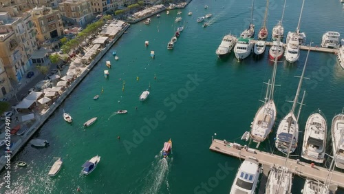 Aerial drone view of the touristic traditional boats and yachts in marina. Birgu city, Malta island photo