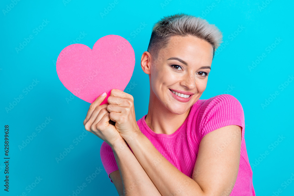 Portrait of gorgeous adorable woman with short haircut wear pink top hold big shape heart postcard isolated on blue color background Portrait of gorgeous adorable woman with short haircut wear pink top hold big shape heart postcard isolated on blue color background