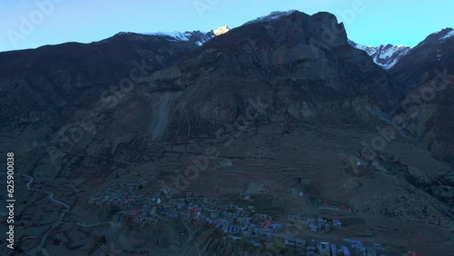 Aerial approaching view Manang village house buildings in high altitudes. Annapurna circuit trek guesthouses. Manang district in Nepal. Himalayas mountain range trekking. photo