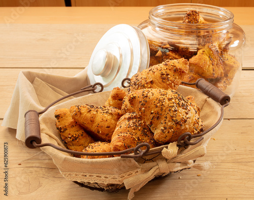 Cruasanes con cereales en cesta y tarro de cristal, vista cenital. Croissants with cereals in basket and glass jar, overhead view. photo