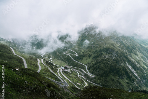 A Winding Mountain Road In Switzerland On A Misty Morning 
 photo