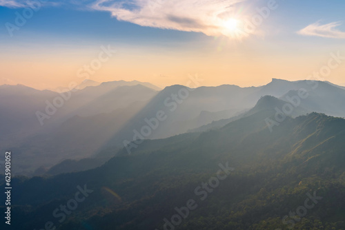 sunset behind mountain range with beautiful sun ray in the northern of thailand (Phu Chi Dao Chiang Rai Province)