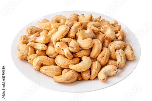 Roasted brown cashew nuts in stack on white plate isolated on white background with clipping path in png file format