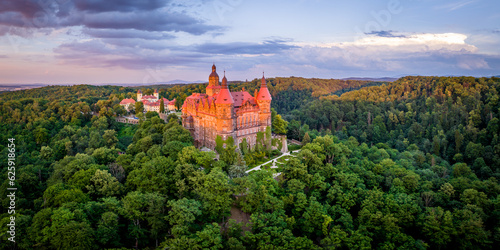 Amazing aerial panorama of a forest and a castle at sunset.