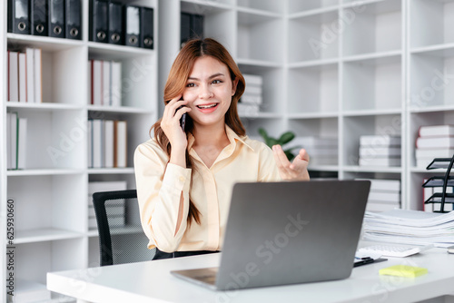 Businesswoman talking on smartphone while working and reading business marketing plan report to analysis investment and planning to management project of business in office