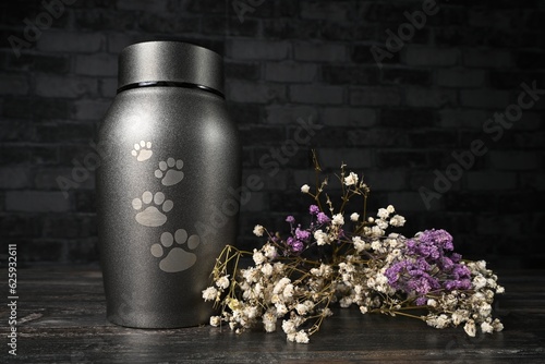 In remembrance of a pet. Pet urn beside a flower bouchet. 