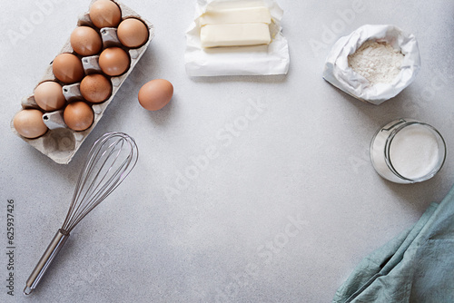Ingredients for baking - Carton of eggs, flour, sugar and butter on concrete background. Recipe or cookbook concept. Copy space, top view