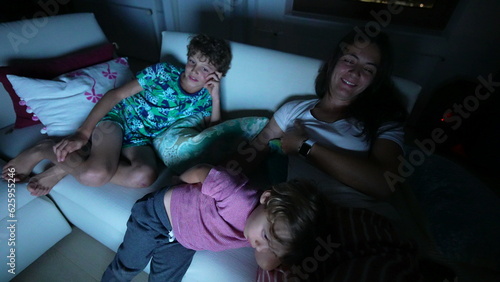 Kids sitting at couch at night watching movie