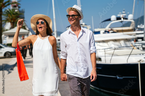 Beautiful young loving couple carrying shopping bags and enjoying travel, vacation together.