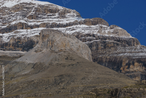 The peak of Monte Perdido in the pyrenees mountains covered in snow over a blue clear sky, Ordesa y Monte Perdido National Park, Aragon, Huesca, Spain