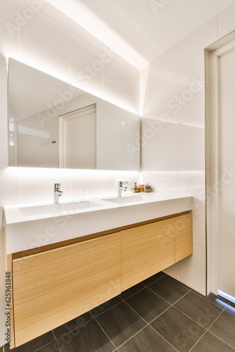 a modern bathroom with black tile flooring and white tiles on the walls, along with a wooden sink vanity