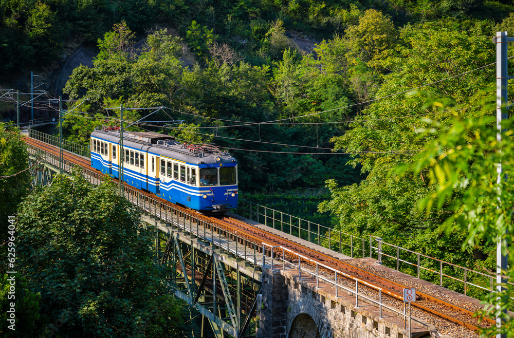 Historic electric train on famous steel bridge in Intragna in