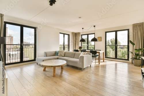 a living room with wood flooring and large sliding glass doors that open onto the balcony overlooking out to the garden