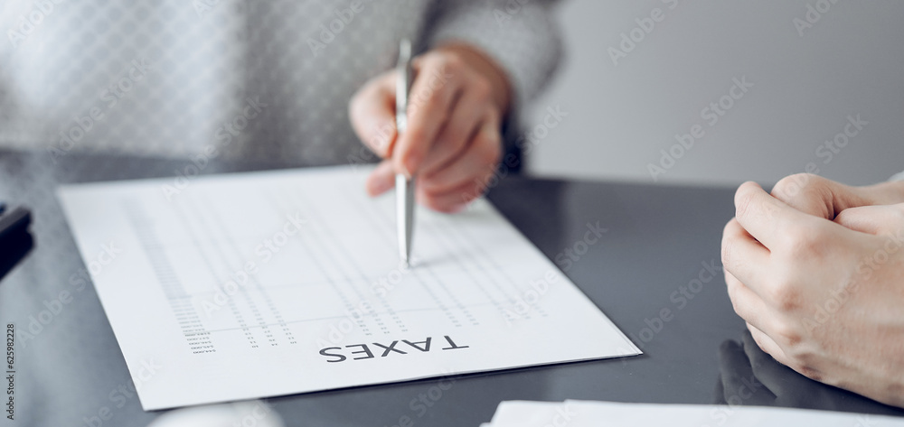 Woman accountant using a calculator and laptop computer while counting taxes for a client. Business audit and finance concepts Woman accountant using a calculator and laptop computer while counting taxes for a client. Business audit and finance concepts