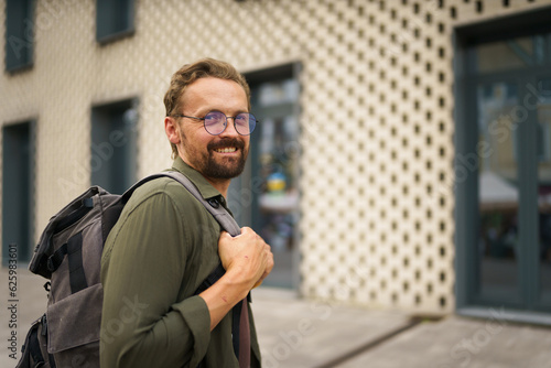 Happy man on way to work as dedicated worker on bustling city street. With cheerful expression and spring in his step, man exudes positivity and joy as he navigates through urban landscape. High