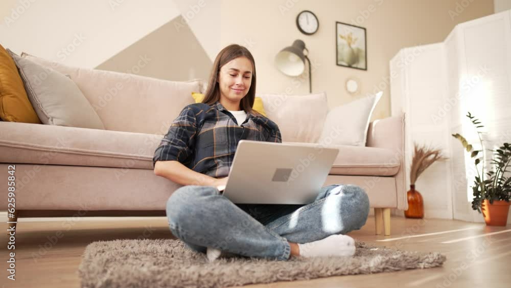 Young brunette woman freelancer in casual clothes works on laptop sits on couch at home. She texting message, sending email or writing article. Remote, distance, freelance work, job concept. Young brunette woman freelancer in casual clothes works on laptop sits on couch at home. She texting message, sending email or writing article. Remote, distance, freelance work, job concept.