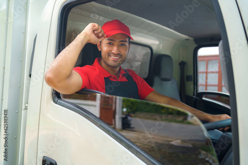 Transport worker moving to new house sitting in cargo truck and smiling ready in service.