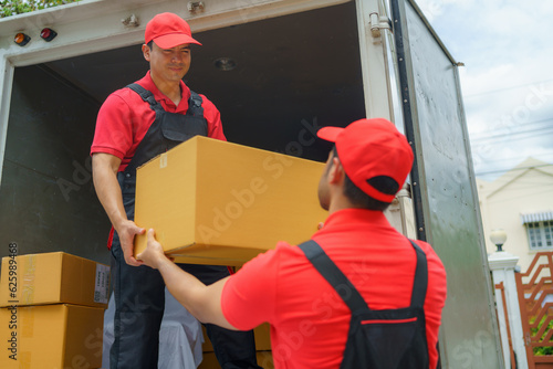 Workers are unloading stuff from a truck to move to a new house.. photo