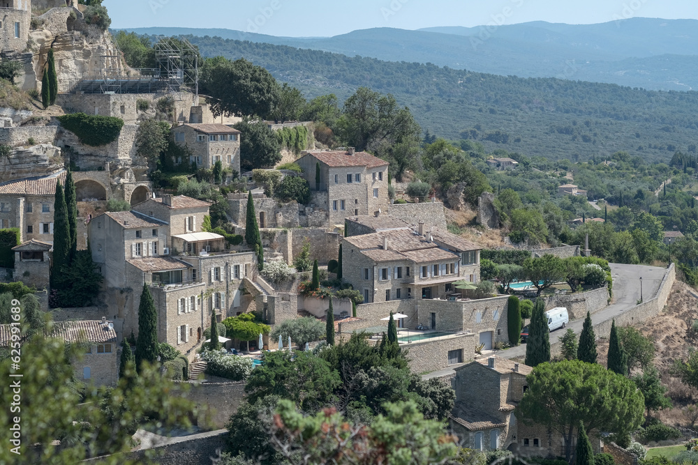 Old medieval town Gordes on the rock, Luberon, Vaucluse, landscape of Provence France, Europe in july. Beautiful ancient buildings with roof tiles. 12th century houses. 