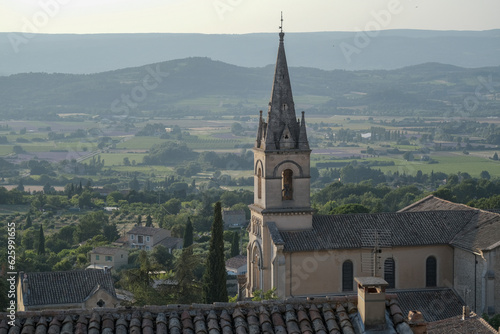 Close up of Saint-Gervais church in of old medieval town Bonnieux, Provence, France. Beautiful view of the valley with lavender fields and vineyards, card with copy space. photo