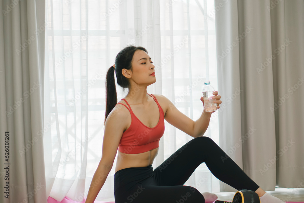 Achieving fitness goals at home, a beautiful Asian woman utilizes her home gym to stay active and maintain her radiant glow.