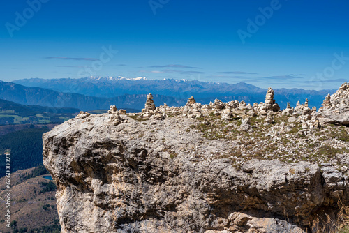 Group of cairns piles of stone on rock against blue sky photo