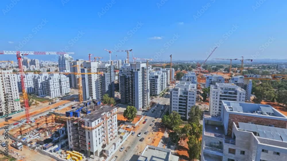Rishon LeZion, Israel, July 10, 2023. Timelapse aerial view of the construction of infrastructure facilities and a new residential area. Operation of tower cranes and construction equipment.