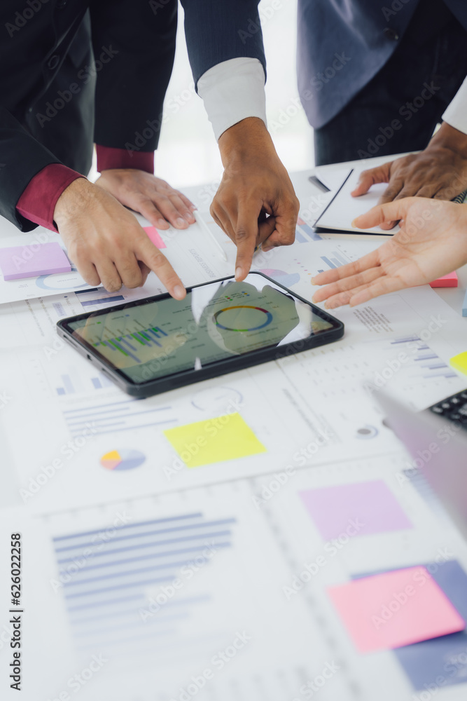 Business documents on office table with smart phone and calculator digital tablet and graph business with social network diagram and two colleagues discussing data working in office Business documents on office table with smart phone and calculator digital tablet and graph business with social network diagram and two colleagues discussing data working in office