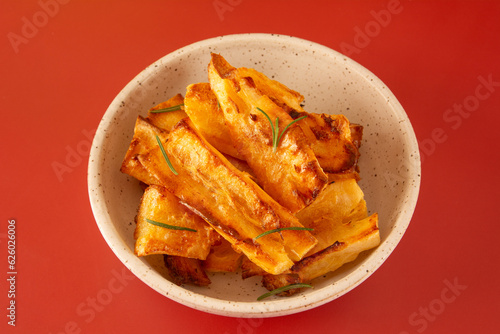Delicious Fried Cassava in Handcrafted White Ceramic Bowl on Red Studio Background
