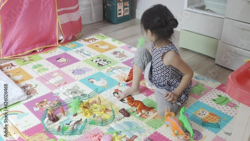 Little girl play anaimal and dinosaur,kid hold dino flying around in her play room.Home deco design. photo