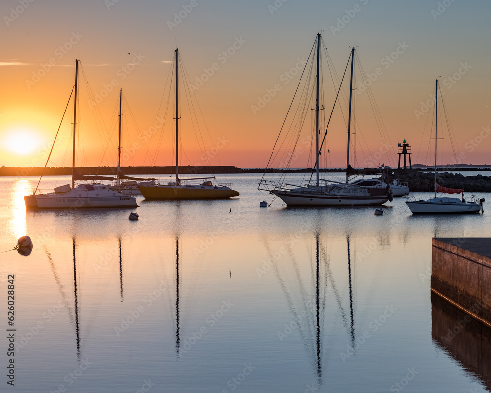 Sunset in the port of Juan Lacaze, with several sailboats anchored in the foreground
