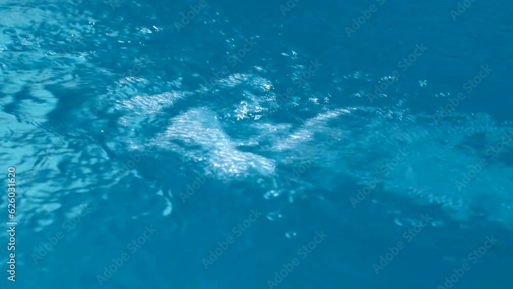 A jet of blue water flows with a strong pressure into the reservoir. A jet of blue water flows with a strong pressure into the reservoir.