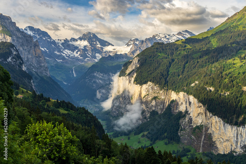 A view of the Swiss Alps and the village of Lauterbrunnen in the Berner Oberland area of Switzerland, with mountains in the background, a valley and chalets in the foreground