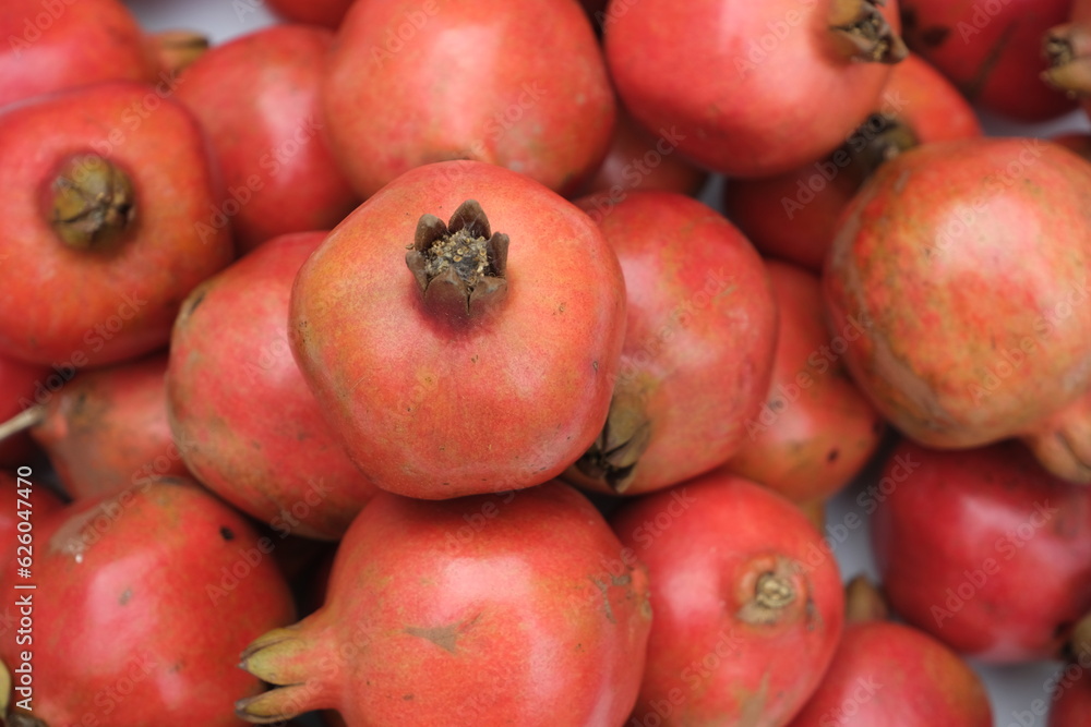 Pomegranates on the counter. Red ripe fruits.Background from whole pomegranates. Pomegranates on the counter. Red ripe fruits.Background from whole pomegranates.